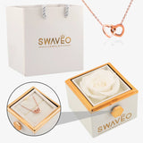 Senvoa white gift bag, white box with white rose, and rose gold heart necklace engraved with names.